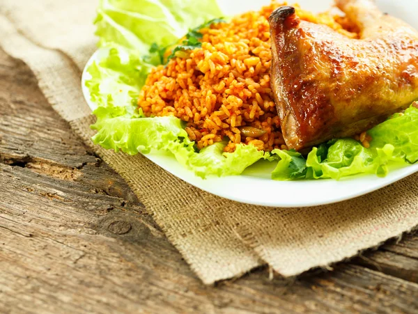 Delicioso plato de muslo de pollo con arroz y hojas de ensalada —  Fotos de Stock