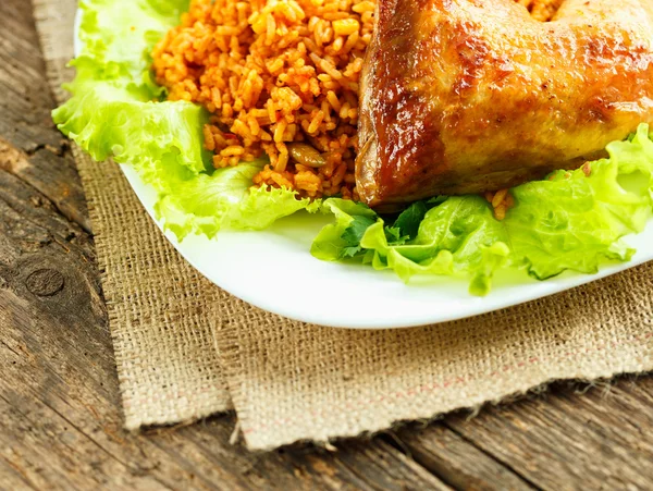 Delicioso plato de muslo de pollo con arroz y hojas de ensalada —  Fotos de Stock