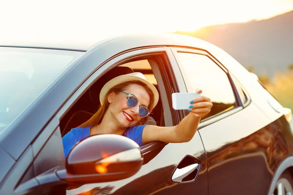 Mujer en sombrero y gafas de sol haciendo autorretrato sentado en el —  Fotos de Stock