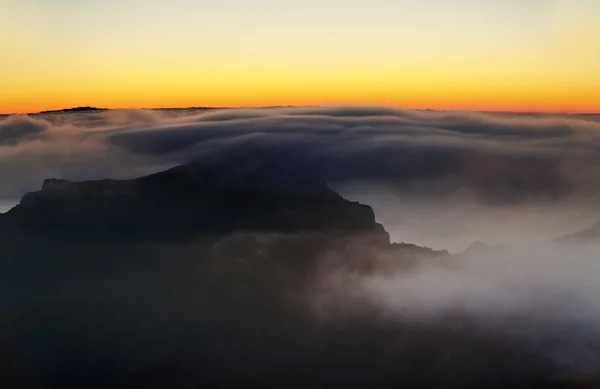 Sunset over the mountains in the clouds — Stock Photo, Image