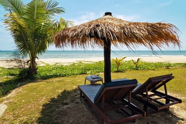 Ξύλινες καρέκλες και ομπρέλες στην παραλία με λευκή άμμο — Φωτογραφία Αρχείου