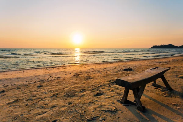 Träbänk på sandstranden — Stockfoto