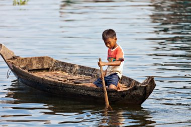 Tonle Sap Gölde yüzen bir tekne üzerinde tanımlanamayan bir çocuk 