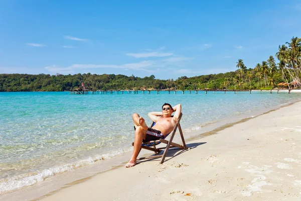 Расслабляющий мужчина на пляже — стоковое фото