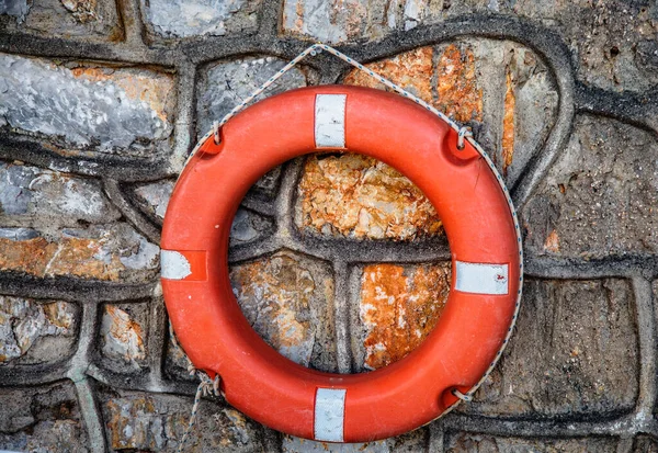 石墙上的红色救生圈水上安全的概念 对溺水者的急救 — 图库照片
