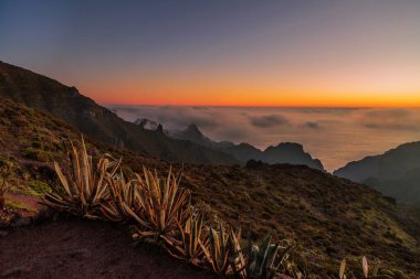 Bulutlardaki dağların üzerinden gün batımının çarpıcı manzarası. Tenerife, Kanarya Adaları. İspanya