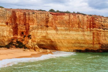 Atlantik kayalık sahili, Algarve, Portekiz 'de kumlu tepeler bulutlu hava manzaralı.. 