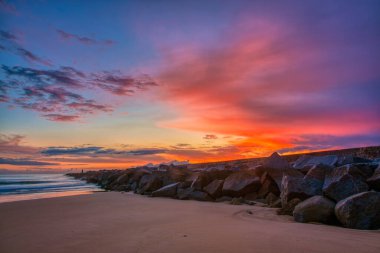 Pier 'den ünlü eski Farol de Portimao molhe este' ye kasvetli günbatımının altında. Portekiz