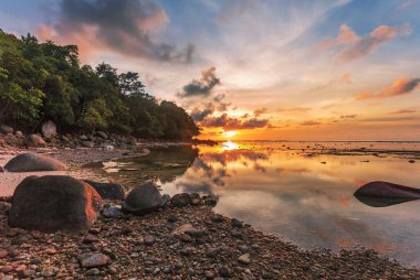 Güzel günbatımında, günbatımında plajda kayalar. Doğa arkaplanı 