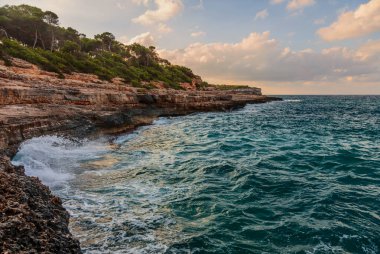 Mandrago sahilinin yakınındaki küçük tropik Borgit plajında gün batımı. Mallorca Adası, İspanya Akdeniz, Balear Adaları.