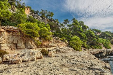 Mavi gökyüzünün altında kayalıklarla kaplı bir manzara. Mallorca Adası, İspanya Akdeniz, Balearic Adaları.
