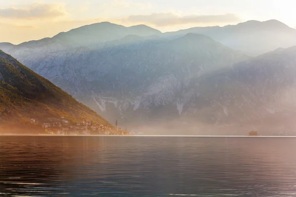 Sunset on the sea with the foggy mountains — Stock Photo, Image