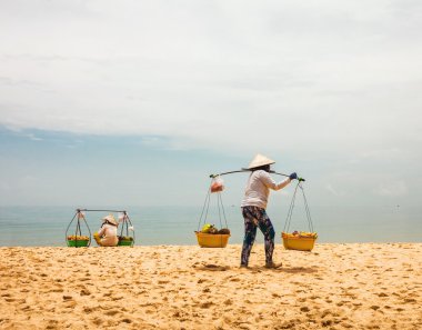 Vietnamca womans Satılık meyve turistlere sunmaktadır.