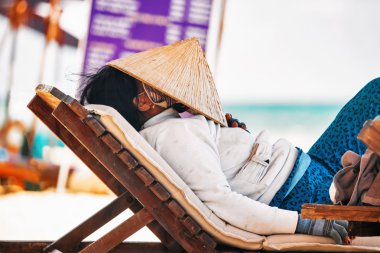 Sahilde bir tembel üzerinde dinlenme Vietnamca meyve pazarlamacı