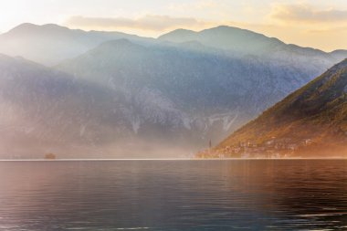 sisli dağlar deniz günbatımı