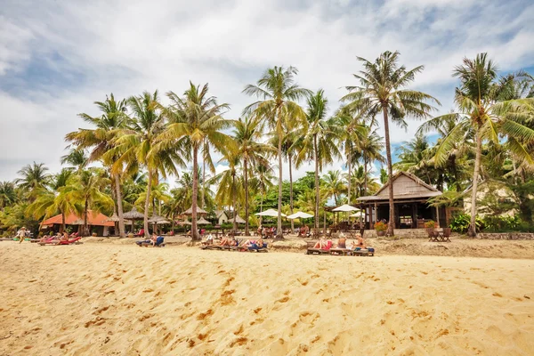 Tourists sunbathing on the sand of a tropical beach — Stock Photo, Image