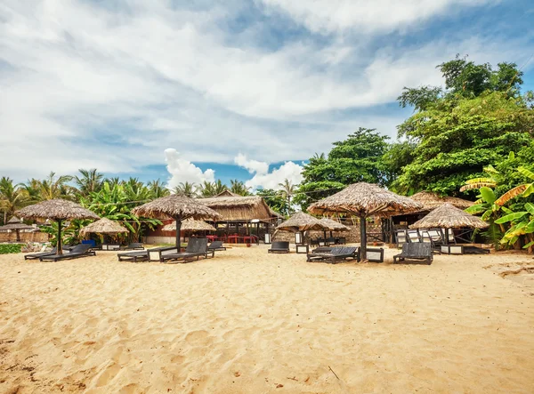 Ξύλινες καρέκλες και ομπρέλες στην παραλία με άμμο — Φωτογραφία Αρχείου