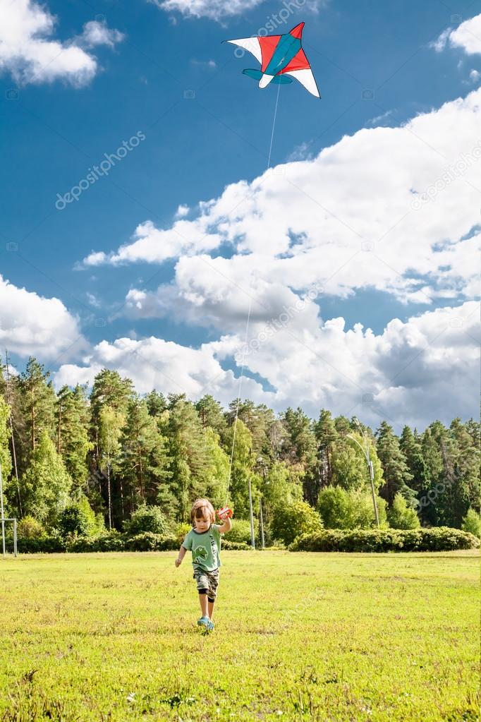 litlle boy runs with kite
