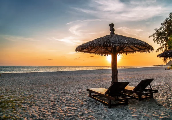 Trä stolar och parasoll på stranden — Stockfoto