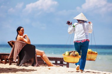 Vietnamca womans Satılık meyve turistlere sunmaktadır.