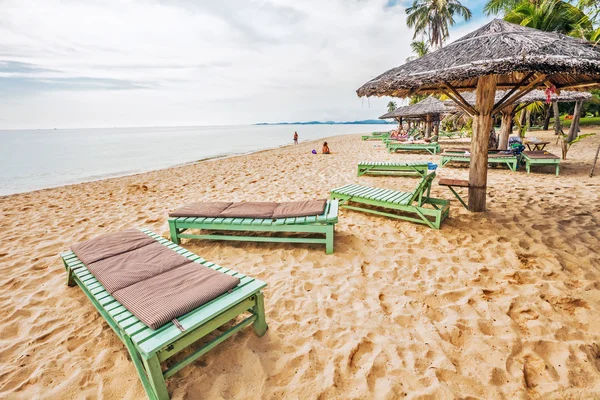 Turistas tomando el sol en la arena de una playa tropical —  Fotos de Stock