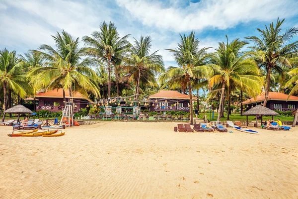 Turisti prendere il sole sulla sabbia di una spiaggia tropicale — Foto Stock