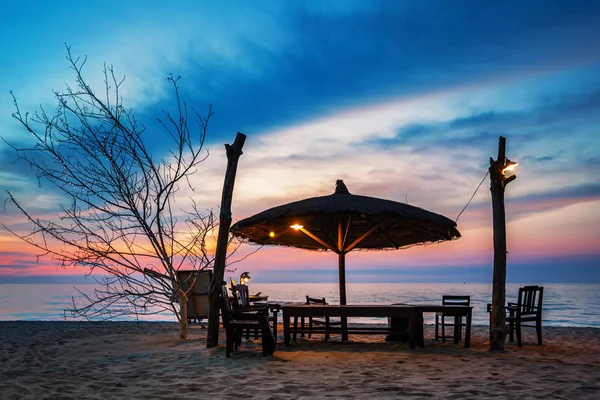 Wooden chairs and umbrella on sand beach — Stock Photo, Image