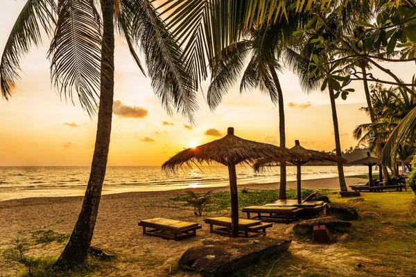 木制椅子和遮阳伞在沙滩上 — 图库照片