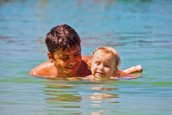 Pai e filho nadando no mar — Fotografia de Stock