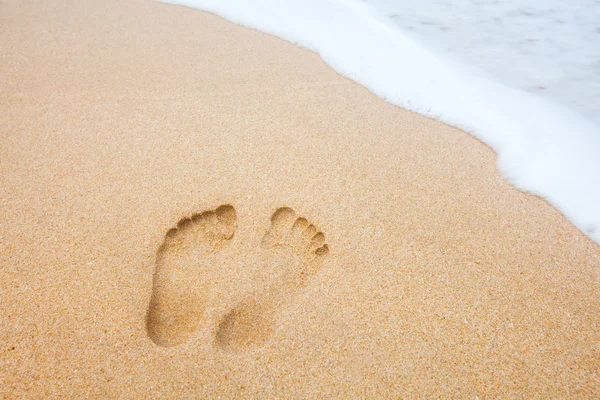 Impronte sulla spiaggia vicino al mare — Foto Stock