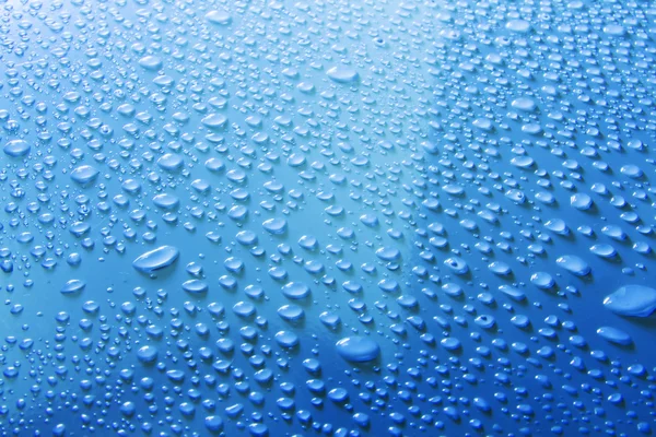 Gotas de agua en la superficie azul — Foto de Stock