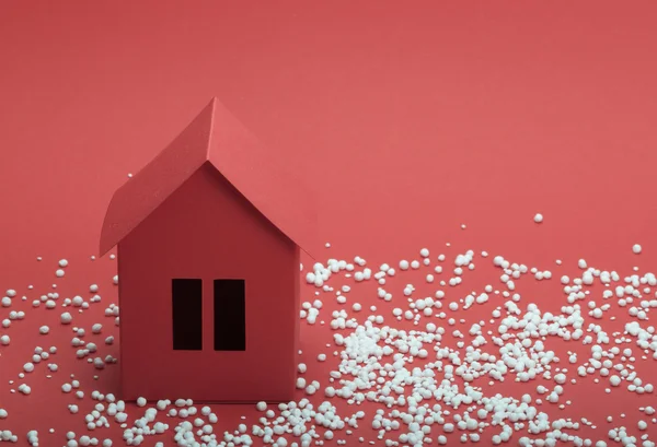 Paper house in snow on red background — Stock Photo, Image