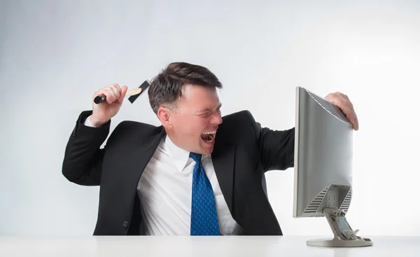 Angry men holding hammer over PC monitor — Stock Photo, Image