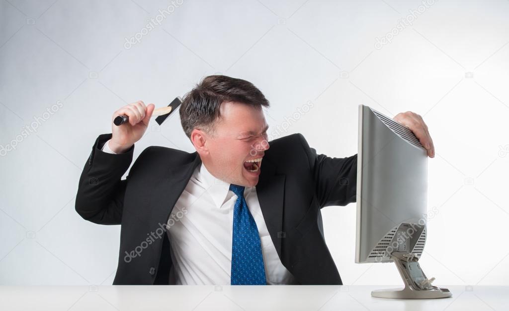 Angry men holding hammer over PC monitor