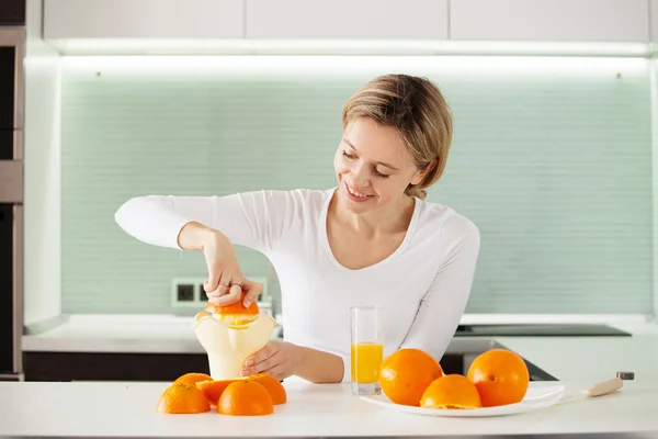 Vuxen kvinna som kokar apelsinjuice på juicen — Stockfoto