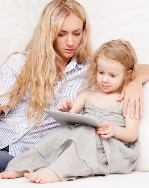 Mãe e filha wiht tablet no sofá — Fotografia de Stock