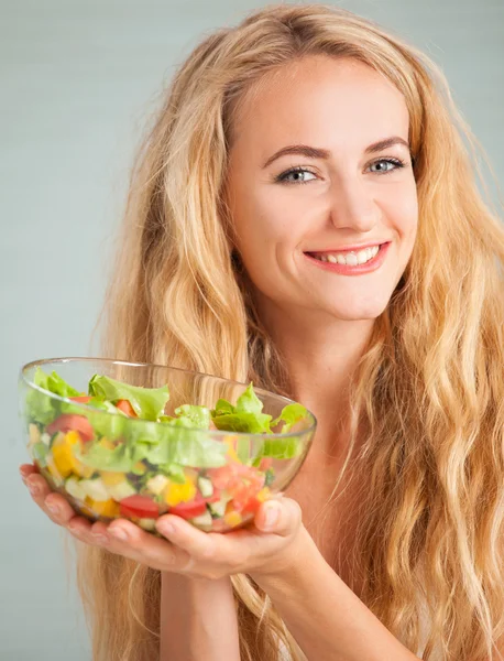 Jovem mulher preparando salada vegetal — Fotografia de Stock