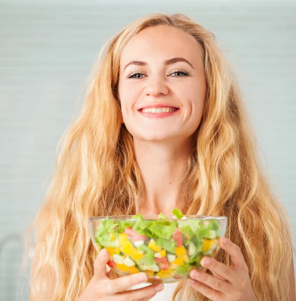 Jovem mulher preparando salada vegetal — Fotografia de Stock