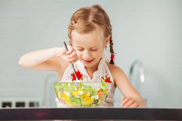 Liten flicka äter grönsakssallad — Stockfoto