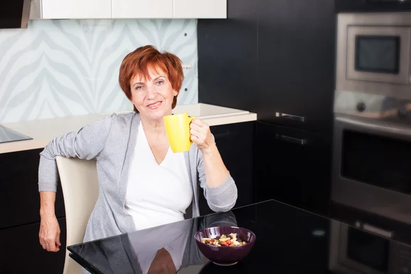 Gelukkig volwassen vrouw op keuken — Stockfoto