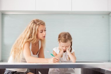 Ebeveyn çocuğun ödevlerini yapmak için yardımcı olur.