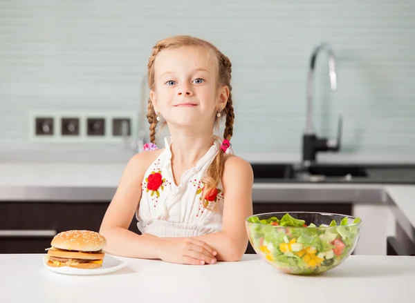 Criança escolhe entre um alimento saudável e não saudável — Fotografia de Stock