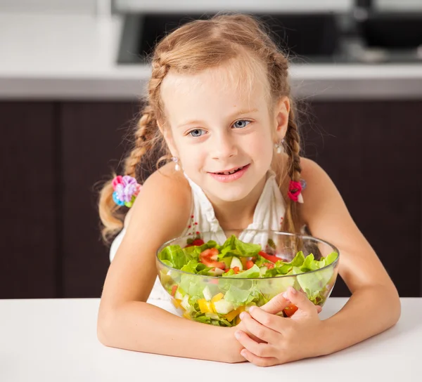 Klein meisje eten plantaardige salade — Stockfoto