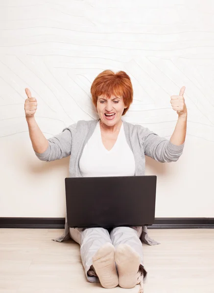 Vrouw zittend op de vloer met laptop — Stockfoto