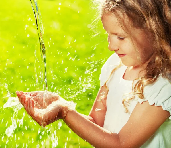 Stream of clean water pouring into kid's hands — Stock Photo, Image