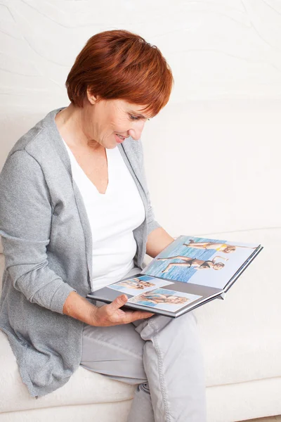 Mujer buscando libro de fotos — Foto de Stock