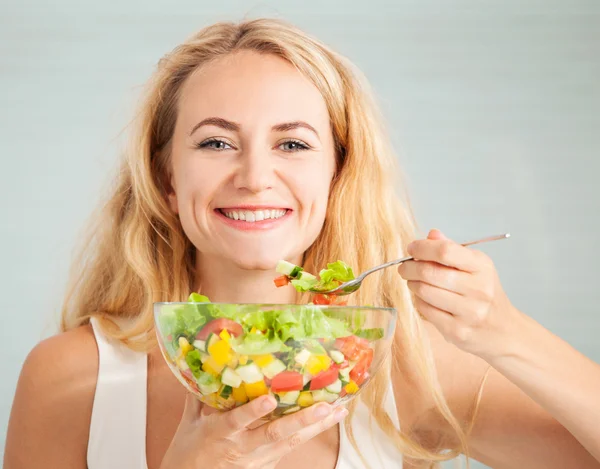 Jovem mulher comendo salada vegetal — Fotografia de Stock