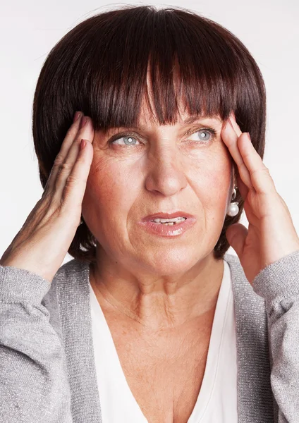 Madura mujer tiene un dolor de cabeza —  Fotos de Stock