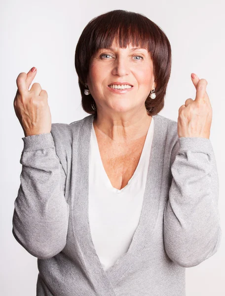 Mature woman with crossed fingers — Stock Photo, Image