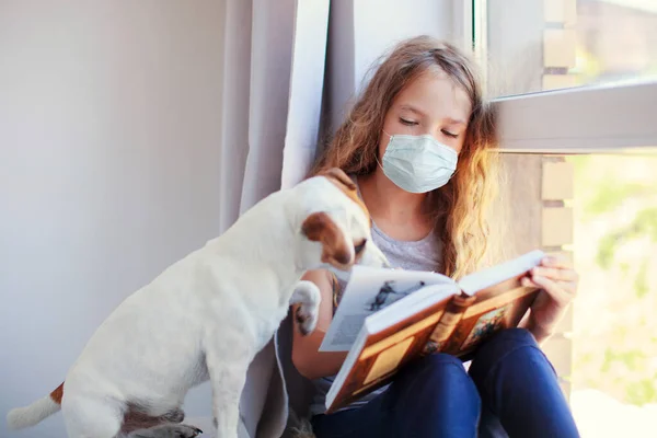 Lány olvasás könyv otthon kutyával — Stock Fotó